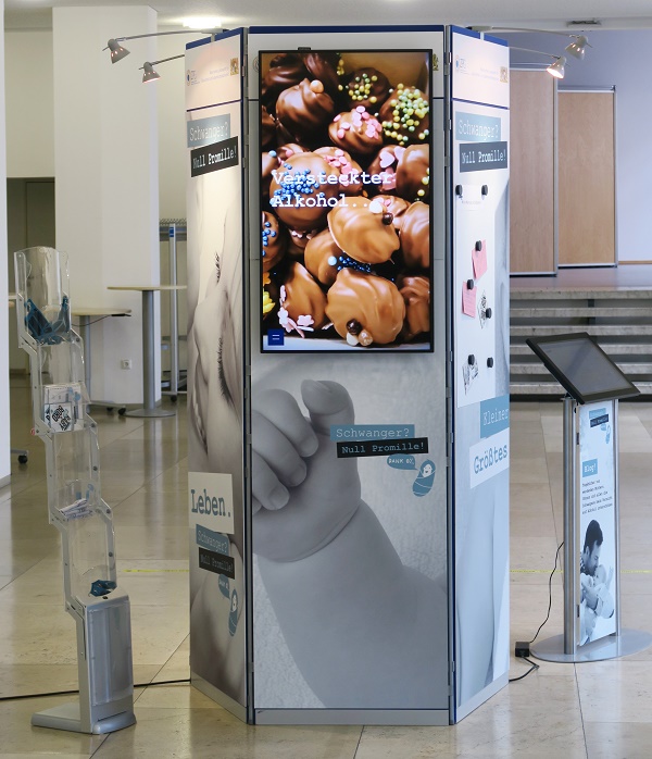 der sechsseitige Medienturm, dessen frontale Seite mit einem TV-Bildschirm ausgestattet ist, dieser gibt Informationen wieder. Außerdem verfügt er über eine Magnetwand für Meinungen und Anregungen der Besucherinnen und Besucher.