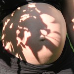 Mein ganz, ganz großer Babybauch kurz ver der Geburt im Schatten einer Palme und Sonnenschein