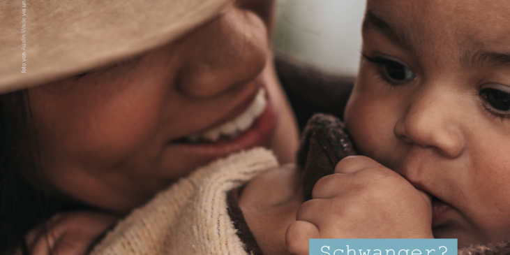 Eine Frau mit Hut lächelt ihr Baby an