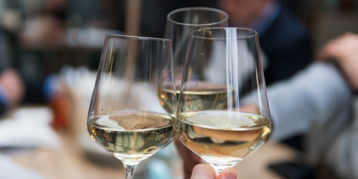Drei Gläser Weißwein beim Anstoßen