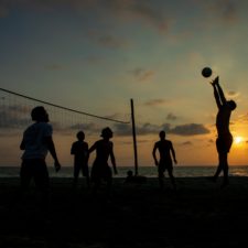 Alkoholverzicht: was passiert mit deinem Körper, wenn du auf Alkohol verzichtest Gesunde sportliche Menschen die keinen Alkohol trinken spielen im Sonnenuntergang am Strand beachvollyball