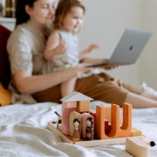 Trotzanfall im Supermarkt - eine Frage der Erziehung? Mutter schaut mit Kleinkind auf den Bildschirm eines Laptops