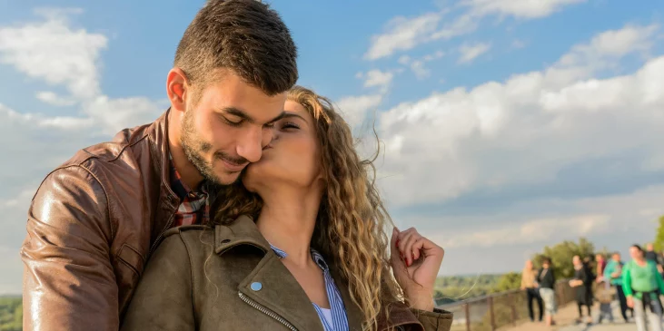 Ein Frau küsst einen Mann auf einem Flusssteg irgendwo in Bayern. Beide haben einen kinderwunsch, wollen schwanger werden und wünschen sich ein Baby