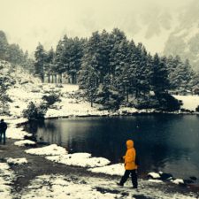 Zwei Menschen beim Winterwandern zwischen Bäumen und Bergen