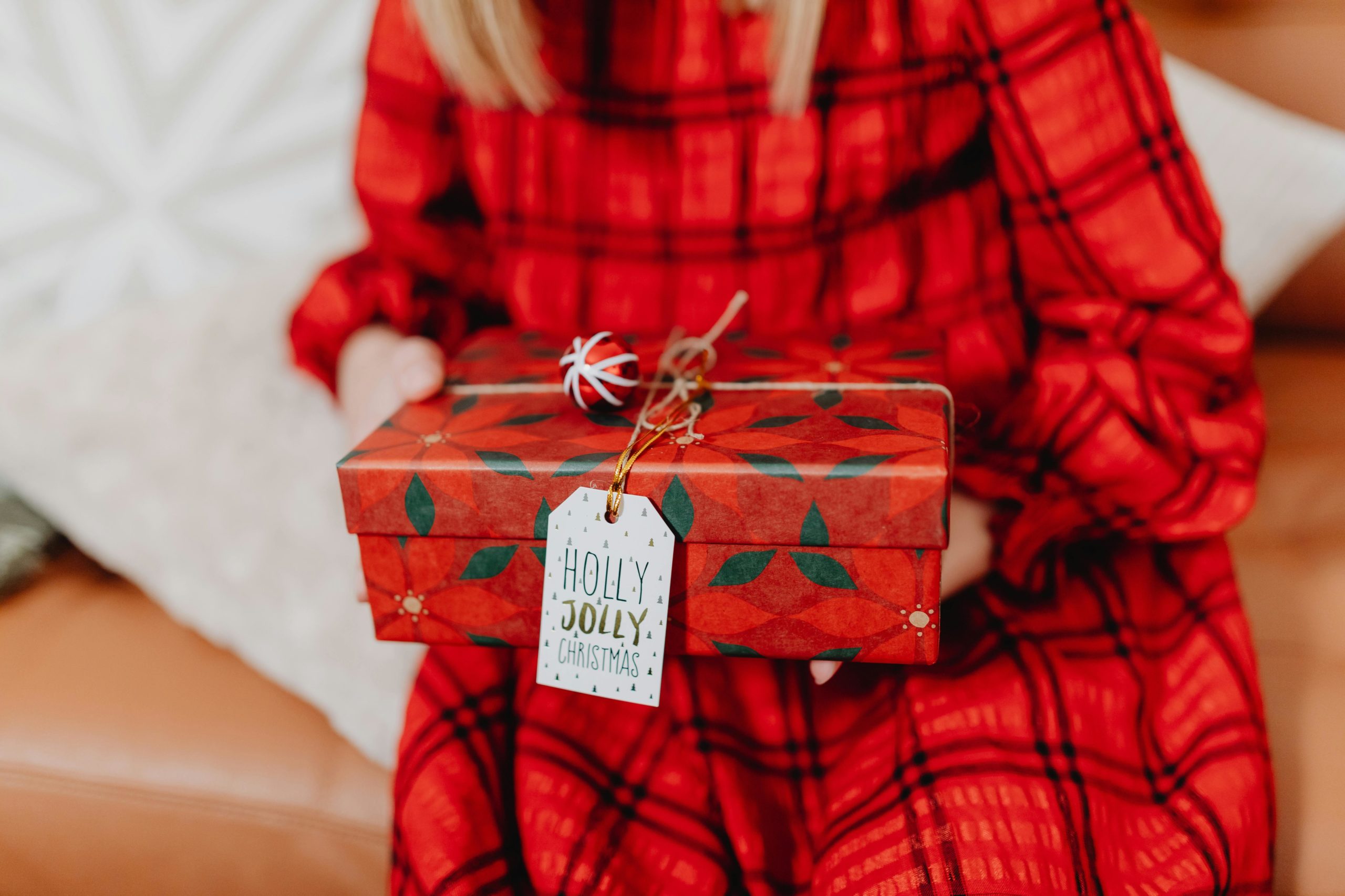 Mädchen hält ein Weihnachtsgeschenk in den Händen