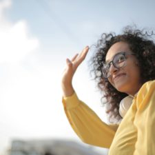 Frau Im Gelben Top Winken