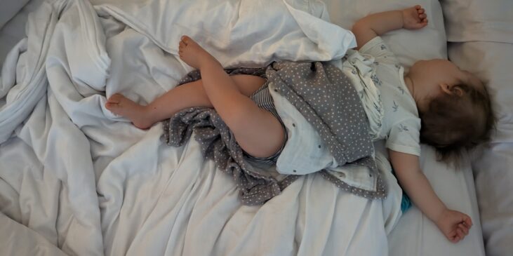 Kind schläft quer im Bett – typische Einschlafposition nach einem langen Tag
