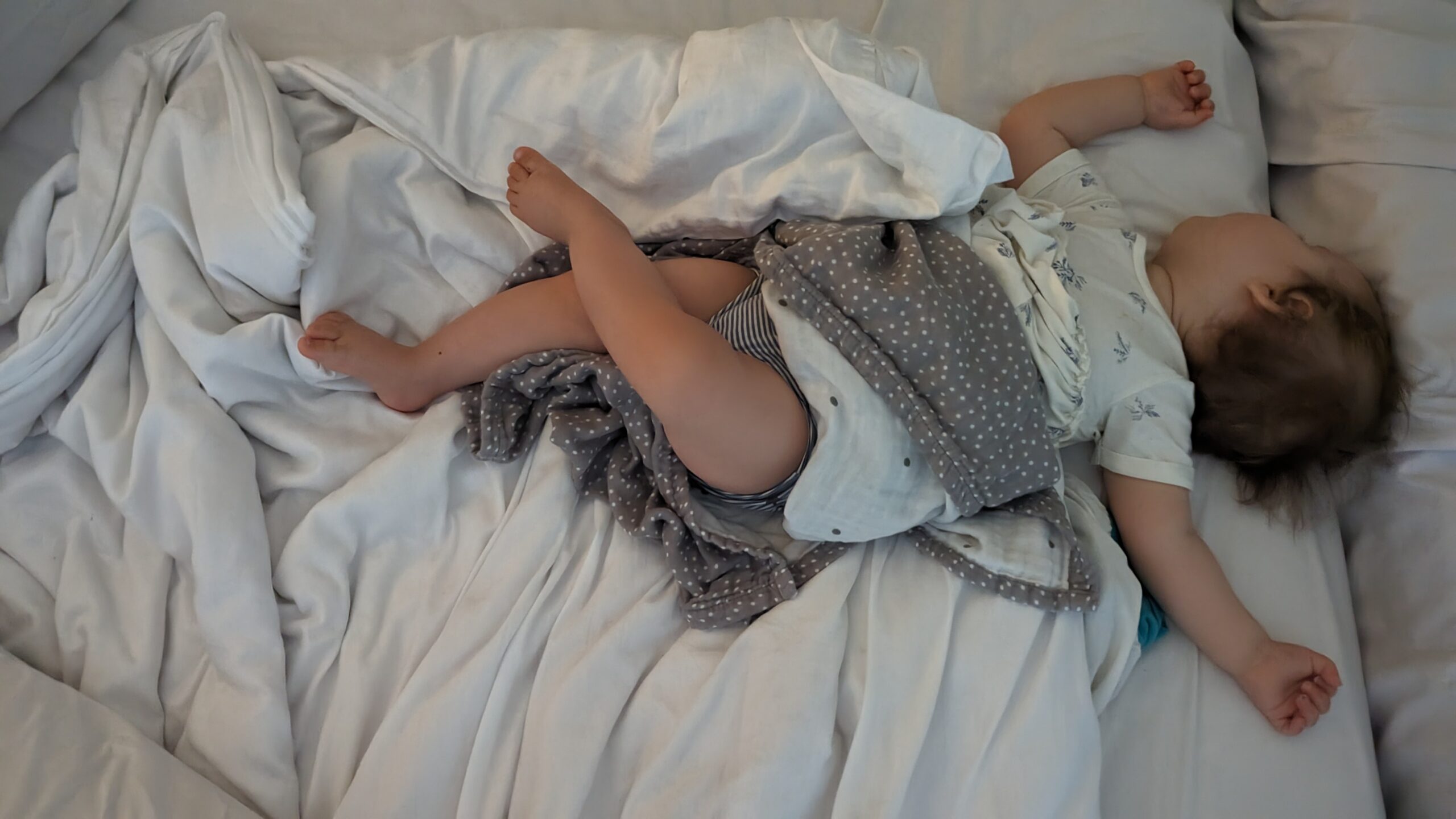 Kind schläft quer im Bett – typische Einschlafposition nach einem langen Tag
