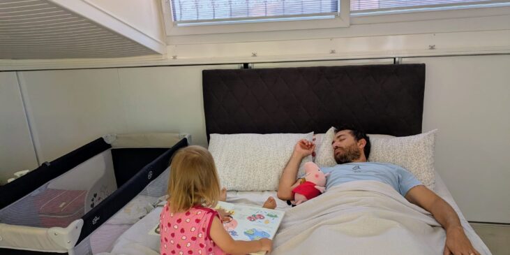 Vater döst mit Kleinkind im Bett ein – Einschlafbegleitung im Familienalltag