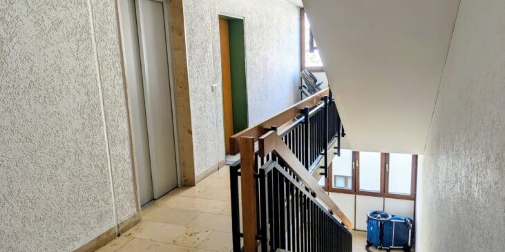 Treppenhaus in einem Mehrfamilienhaus mit Aufzug und Geländer – hier hallen Schritte und Kinderlärm oft laut wider.