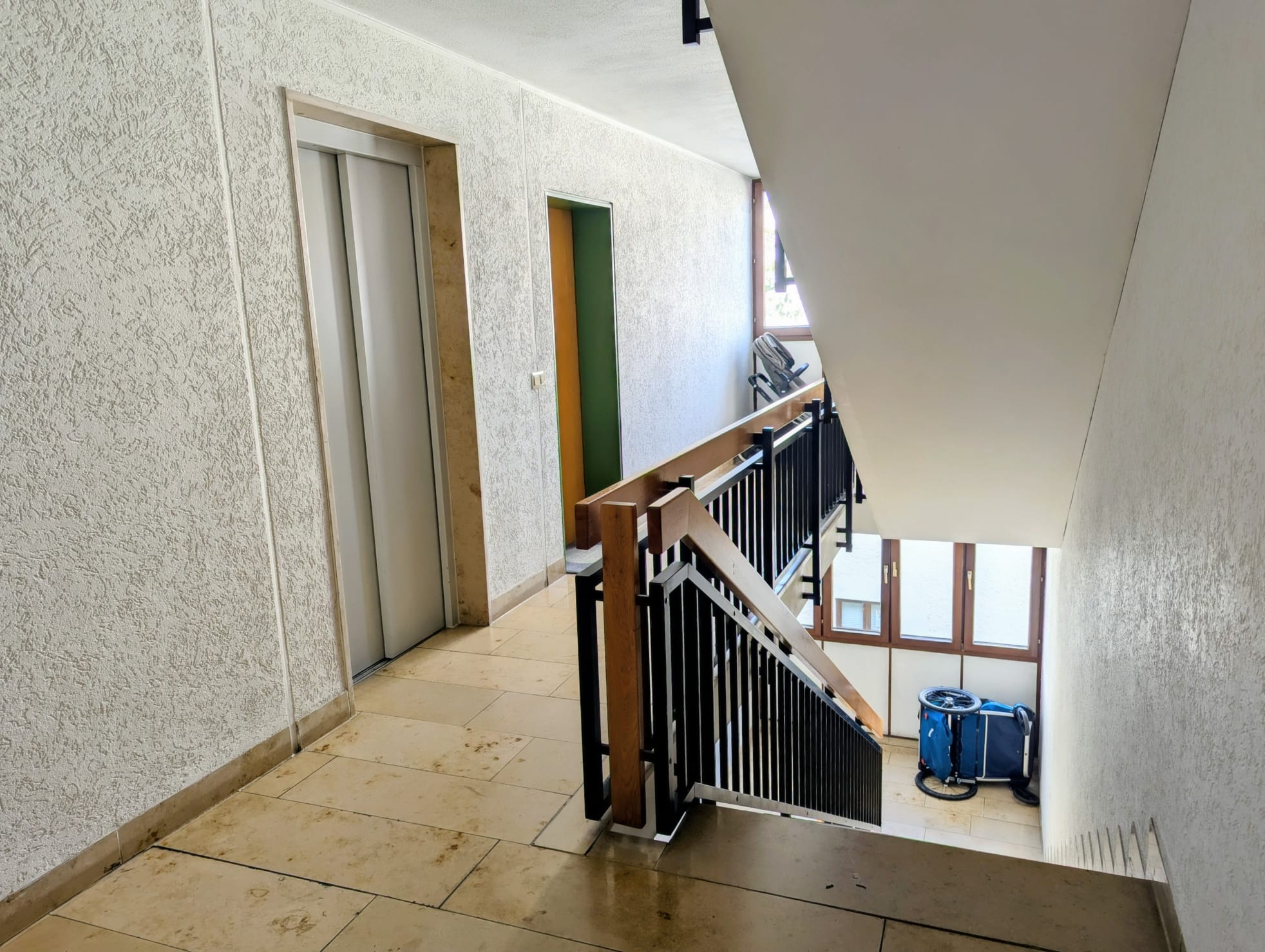 Treppenhaus in einem Mehrfamilienhaus mit Aufzug und Geländer – hier hallen Schritte und Kinderlärm oft laut wider.