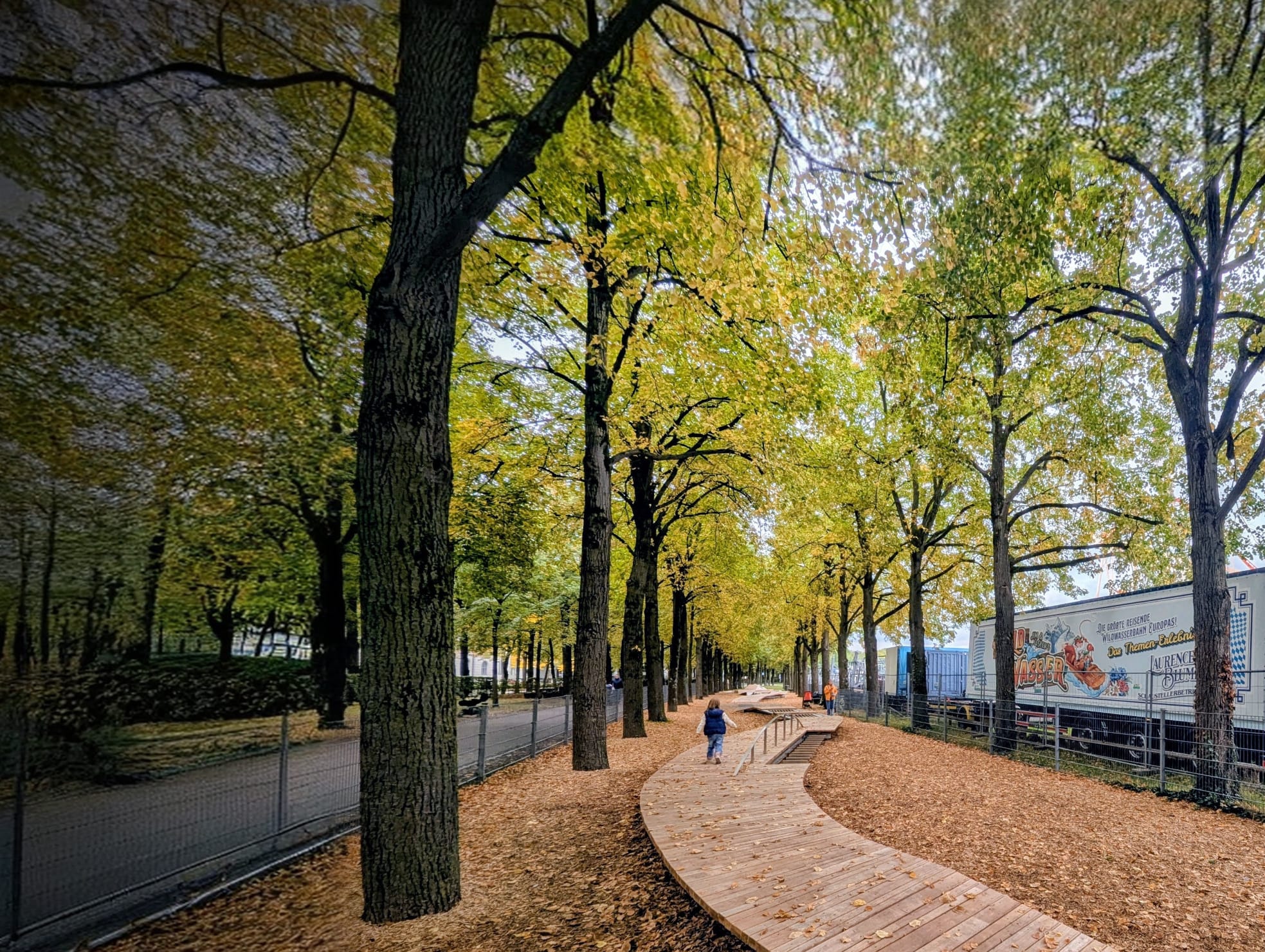 Kleinkind von hinten auf einem Holzweg am Spielplatz – Sinnbild für individuelle Wege.