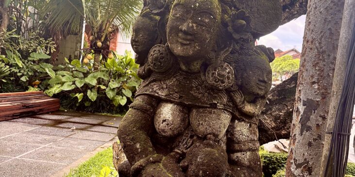 Eine Statue aus Stein auf Bali, die eine stillende Mutter darstellt