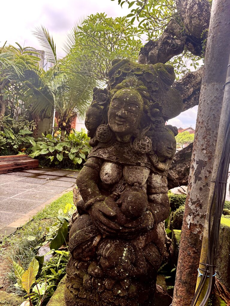 Eine Statue aus Stein auf Bali, die eine stillende Mutter darstellt