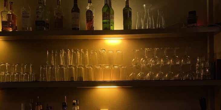 Bar mit Alkoholflaschen und Gläsern in einer gemütlichen Bar